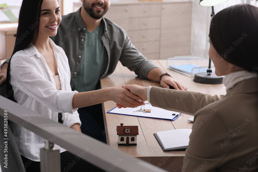Obraz premium Real estate agent shaking hands with client in office, closeup. Mortgage concept