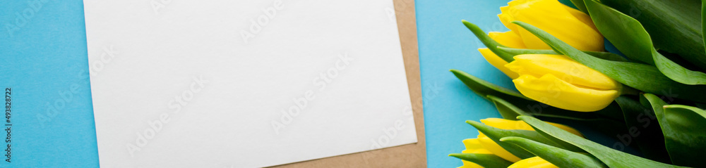 Banner with white paper for text on blue background and yellow tulips. A spring holiday greetings Banner with white paper for text on blue background and yellow tulips. A spring holiday greetings