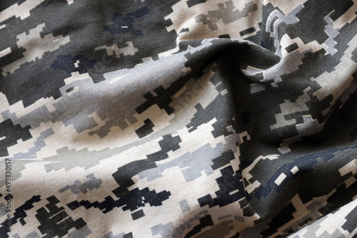 Fabric with texture of Ukrainian military pixeled camouflage. Cloth with camo pattern in grey, brown and green pixel shapes. Official uniform of Ukrainian soldiers photo