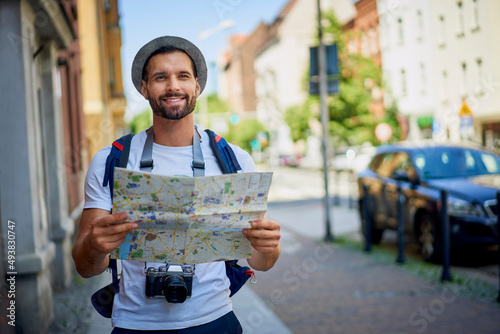 Male tourist with map in visiting European city in summer..Young man exlporing city photo