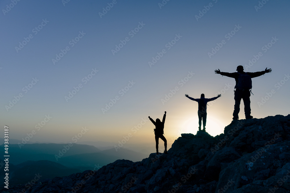Teamwork couple climbing and reaching mountain peak