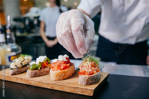 The chef prepares sandwiches seafood. The hand and sandwiches