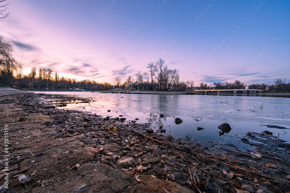 Abendstimmung über einem zugefrorenen See in Bukarest im Winter