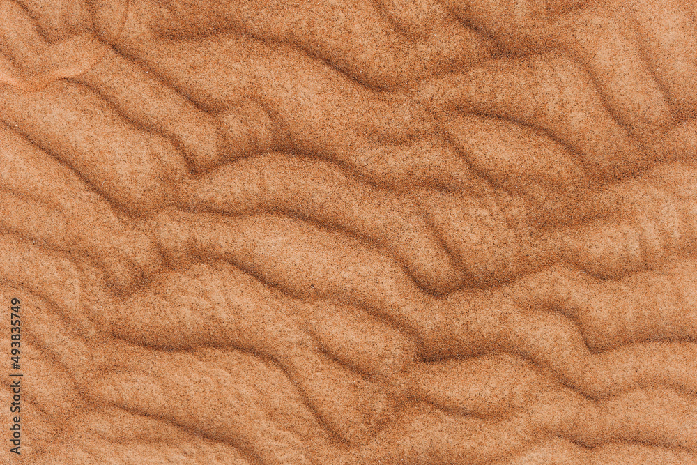 Texture of the sand in the desert. Wavy sand background. Top view Texture of the sand in the desert. Wavy sand background. Top view