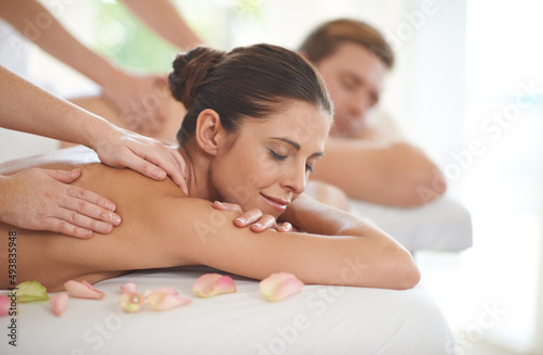 Enjoying a day of pampering. A husband and wife lying receiving massages at a spa.