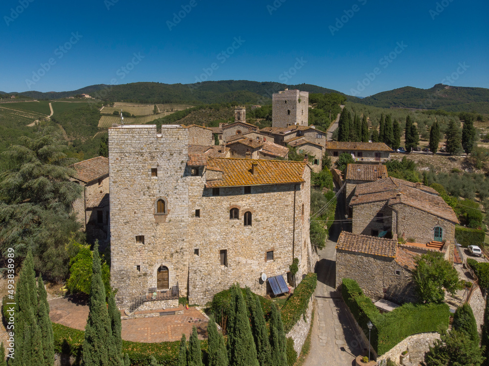aerial view of old town in tuscany country - medieval castle - blue sky and green land