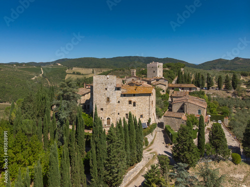 aerial view of old town in tuscany country - medieval castle - blue sky and green land