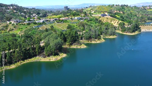 Panorama of Lake Hollywood Reservoir surrounded by steep hills covered in natural foliage is a favorite place for tourists and active people looking to jog, bike ride or walk.    