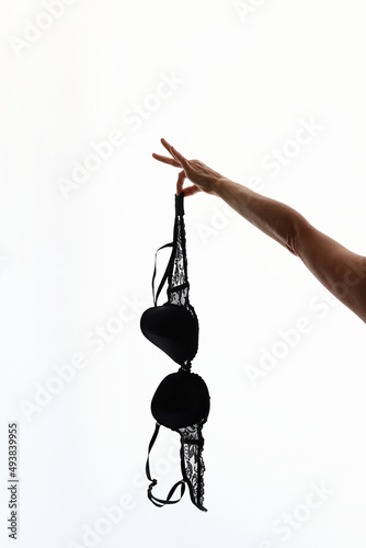 Woman hand holding a brassier vertical photo. feminism concept