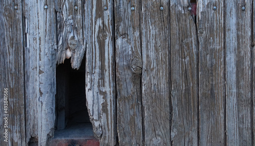 Alte verwitterte Holzbretterwand mit abgebrochener Holzlatte photo