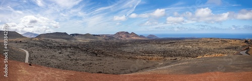 Panoramic view of dormant volcanoes in Timanfaya Nationl Park from Islote de Hilario in Lanzarote, Spain on 9 March 2022