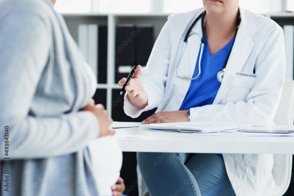 Everything looks good.... Cropped shot of an unrecognizable female doctor consulting with a pregnant patient at a hospital during the day. Everything looks good.... Cropped shot of an unrecognizable female doctor consulting with a pregnant patient at a hospital during the day.