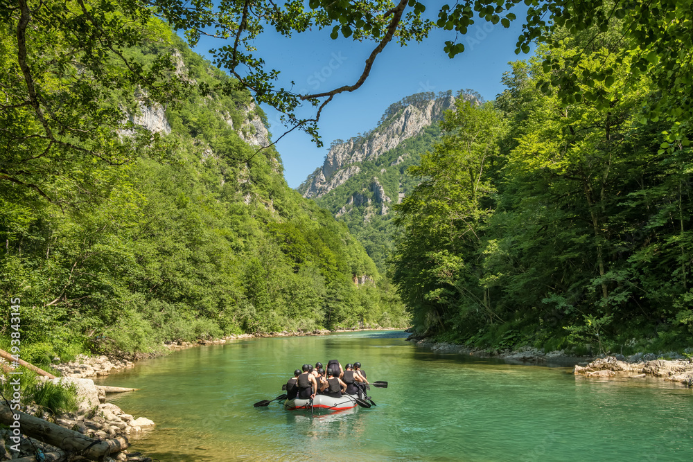Group of unidentified tourists on a rafting boat on Tara river in Montenegro - obrazy, fototapety, plakaty 