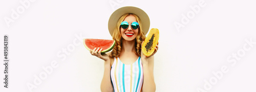 Summer portrait of happy smiling young woman with slice of watermelon and papaya wearing straw hat  sunglasses  on white background