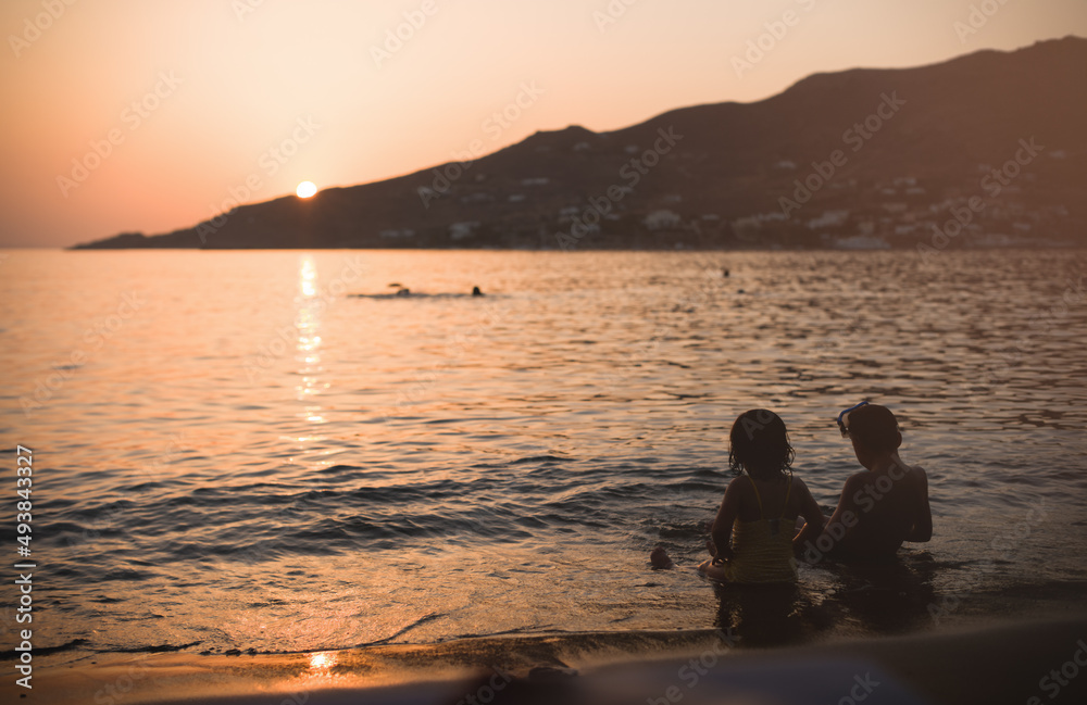 Kids in the water. Family holiday on the coast of Greece is idyllic, disconnect from the hustle and bustle of city life . Young children enjoy the coast of Greece in the sunlight sunset. Vintage image
