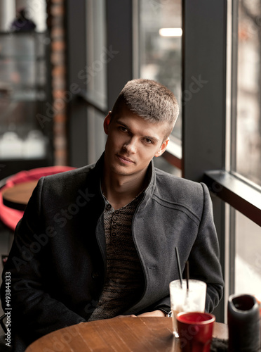 handsome man sitting in a cafe by the window