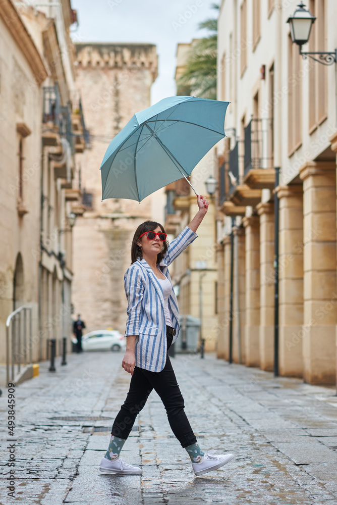 Woman walking down the street on a rainy day with umbrella Woman walking down the street on a rainy day with umbrella
