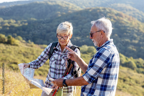 Mature couple in nature looking on map to find road to home
