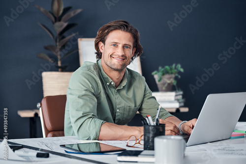 Im in full work mode. Portrait of a handsome young businessman working on a laptop in his office.