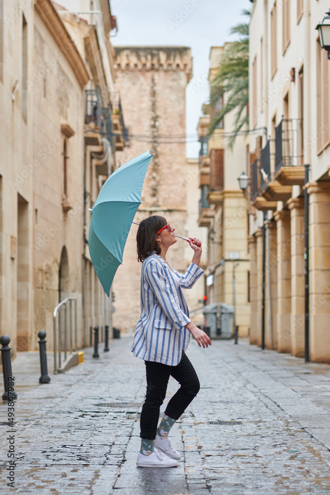 Woman walking down the street on a rainy day with umbrella
