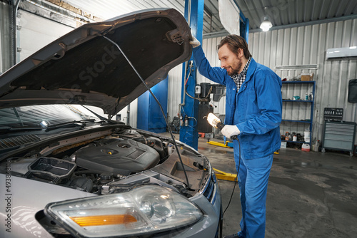 Man inspecting engine compartment in the service center