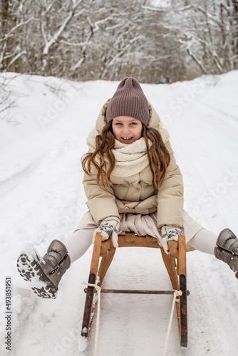 blonde girl rides a sleigh, laughs