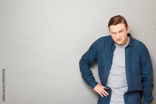 Portrait of disgruntled mature man holding hand on hip © Andrei Korzhyts