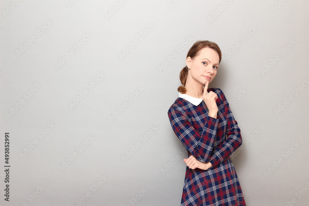 Portrait of serious young woman touching chin with finger and thinking Portrait of serious young woman touching chin with finger and thinking
