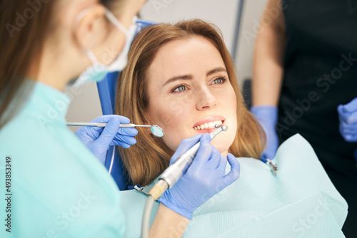 Dentist performing teeth treatment with dental device