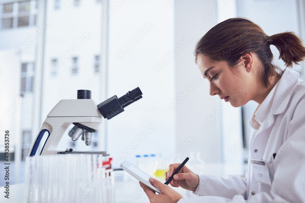 Research is only one part of the job. Shot of a focused young female scientist working on a digital tablet while being seated inside of a laboratory. Research is only one part of the job. Shot of a focused young female scientist working on a digital tablet while being seated inside of a laboratory.