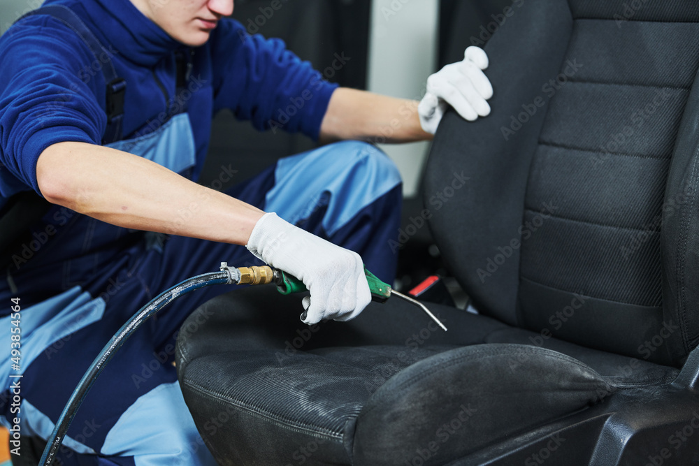 automobile detailing. Car seat cleaning with compressed air Stock Photo
