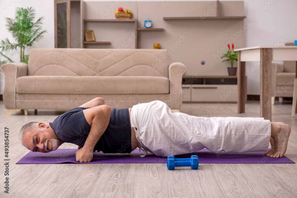 Old man doing sport exercises at home Old man doing sport exercises at home