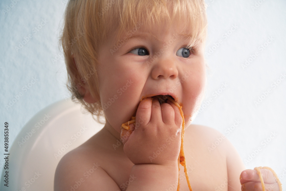 Little baby boy eating spaghetti bolognese. Cute kid making a mess. Little baby boy eating spaghetti bolognese. Cute kid making a mess.