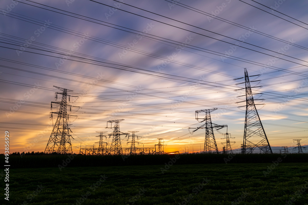 Fototapeta premium In the evening, the silhouette of high voltage towers