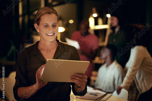 I have everything saved on here for my meeting tomorrow. Shot of a businesswoman using a digital tablet in an office at night.