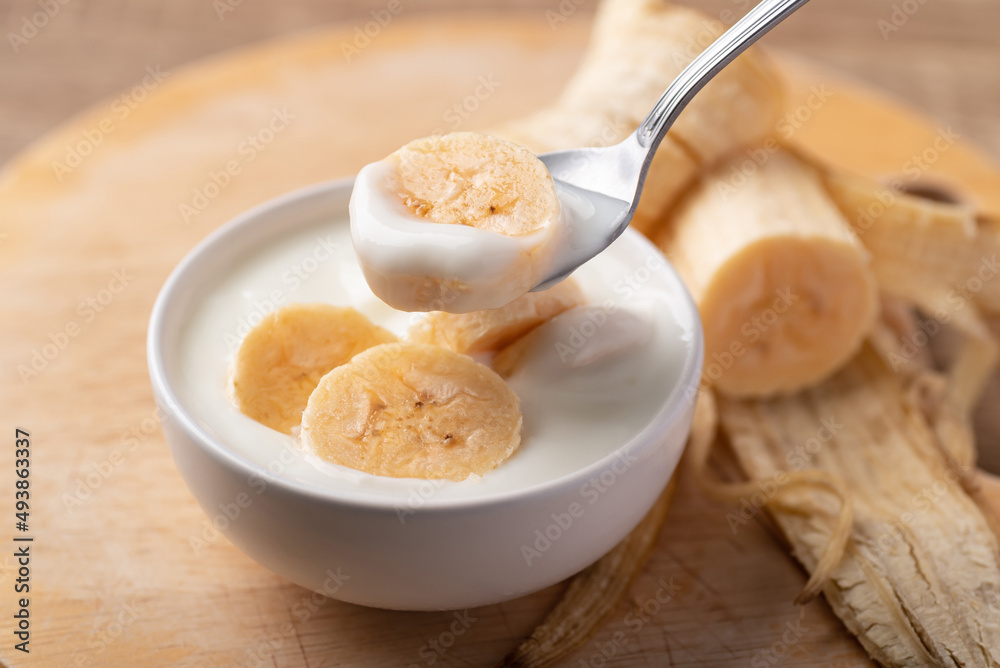 Yogurt with banana in bowl eating by spoon, Healthy food Yogurt with banana in bowl eating by spoon, Healthy food