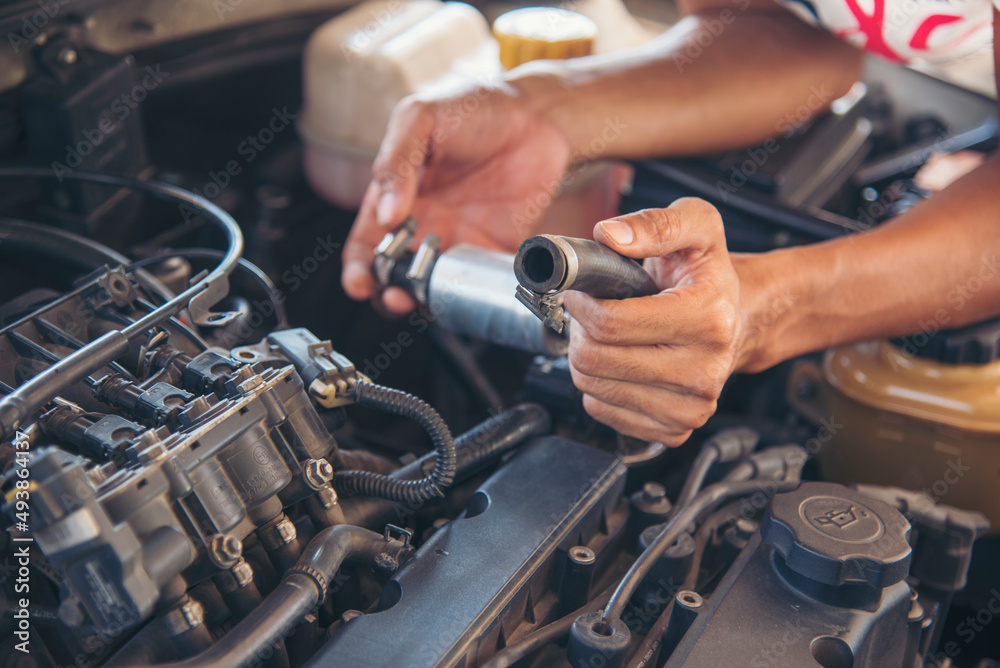 Close up Car Mechanic man hands repairing car auto repair shop. Man hands fixing machinery vehicle mechanical service. open vehicle hood checking up auto mobile. Vehicle Car maintenance engineer.
