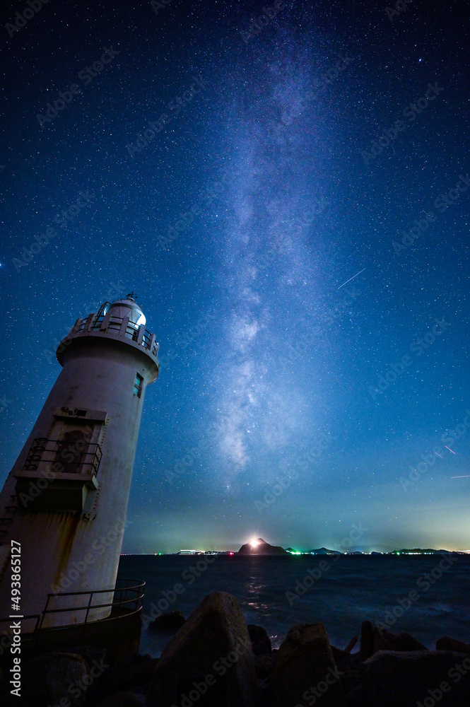 The lighthouse emitted shining rays both in the sky and at sea.