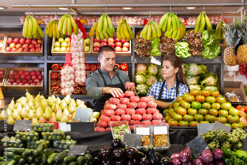 Portrait of male and female shop assistants working responsibly in fruit and vegetable shop
