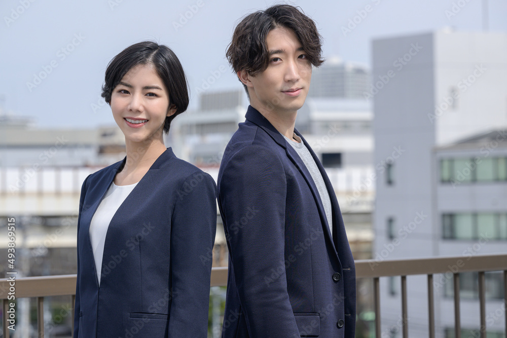Man and woman in suits with building background Man and woman in suits with building background
