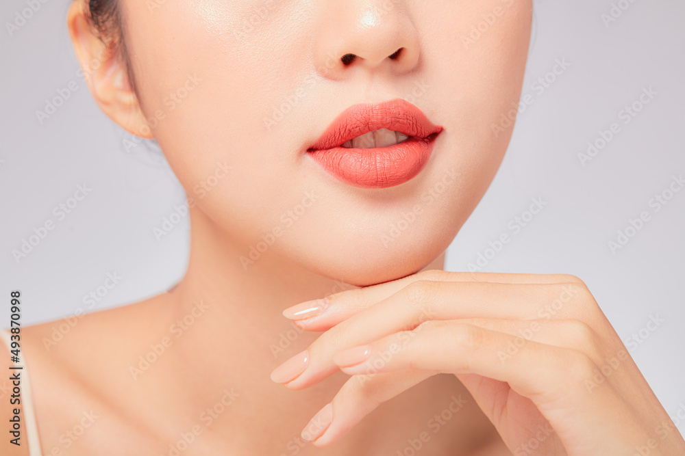 A close view of model showing lip posing with hand for cosmetic advertising A close view of model showing lip posing with hand for cosmetic advertising