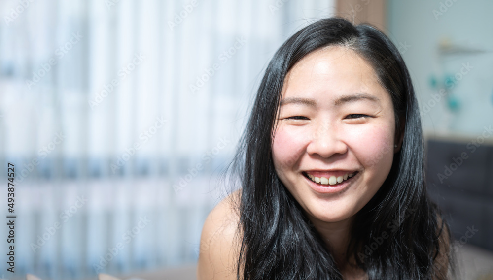 Close up to Confident Young Asian small eye woman is smiling in her bedroom. Close up to Confident Young Asian small eye woman is smiling in her bedroom.