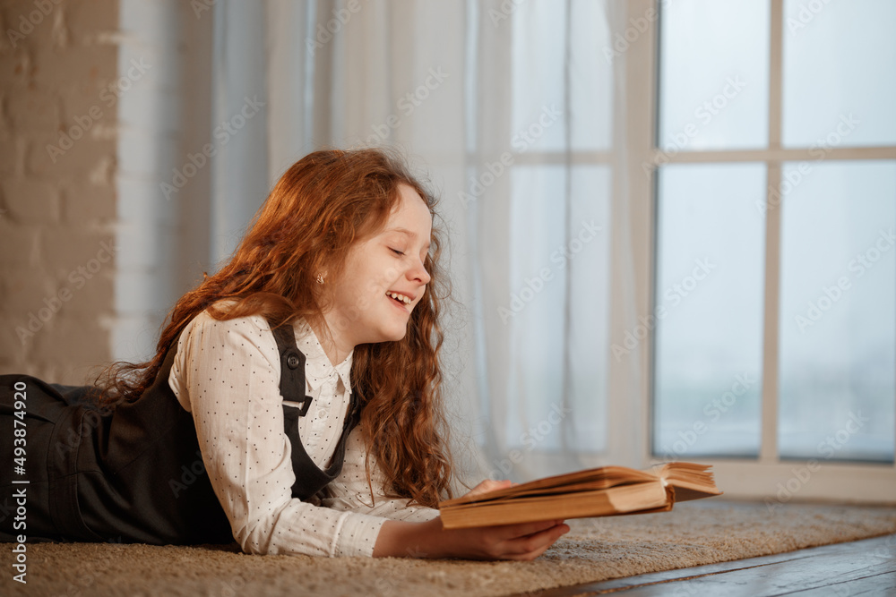Schoolgirl reading the book at home. Schoolgirl reading the book at home.