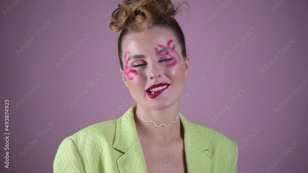Young, beautiful woman professional make up artist with lipstick marks smile at pink background, beauty girl advertises fashion cosmetic at her video blog, smiling pretty. 4k high quality video Young, beautiful woman professional make up artist with lipstick marks smile at pink background, beauty girl advertises fashion cosmetic at her video blog, smiling pretty. 4k high quality video