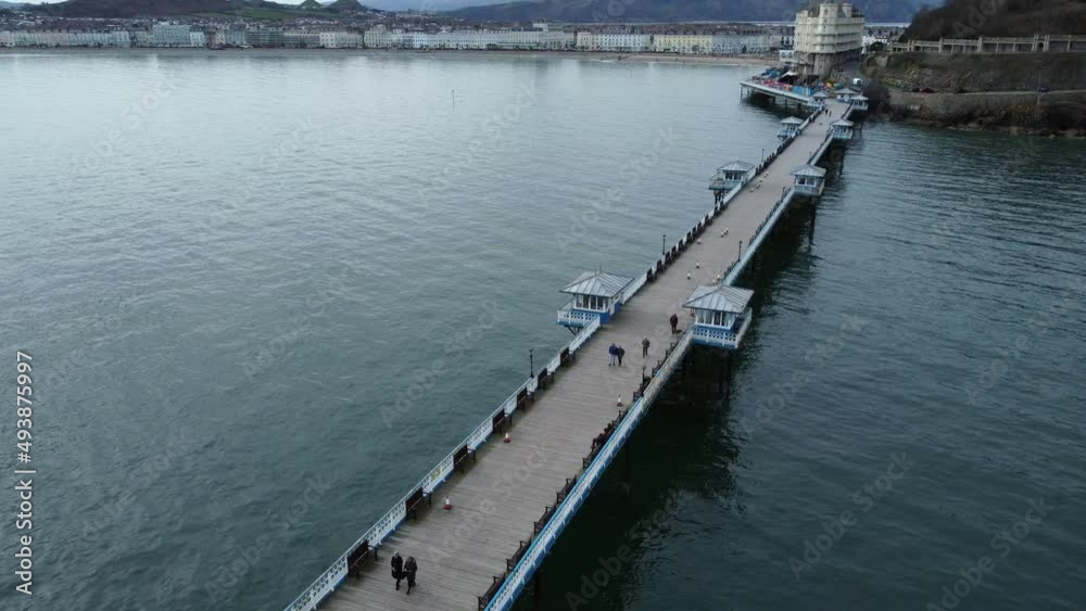 Llandudno pier Welsh Victorian boardwalk resort promenade aerial low tracking view Llandudno pier Welsh Victorian boardwalk resort promenade aerial low tracking view