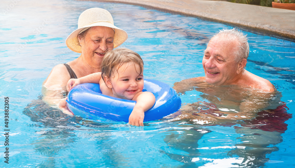 A child with a couple of seniors in the pool