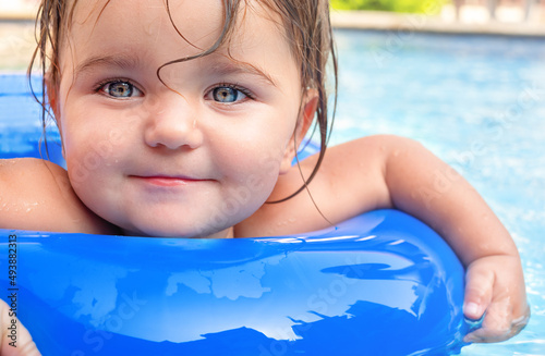 Cute baby girl swims in the pool