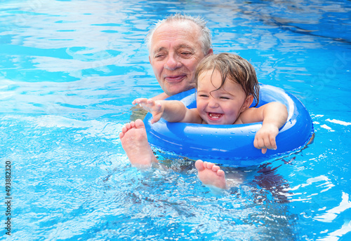 A child with a senior swims in an inflatable floating
