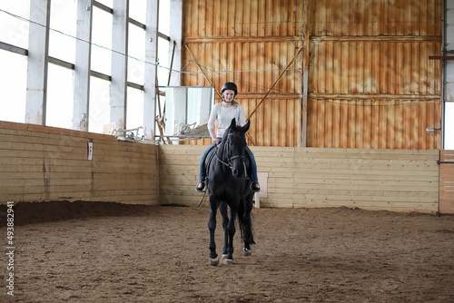 People on a horse training in a wooden arena © alexkich