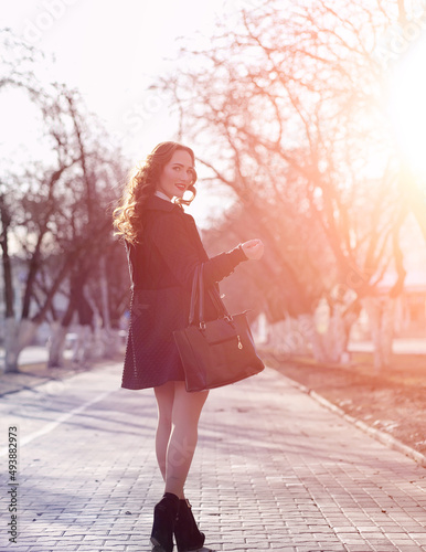 Girl business woman in the spring on a walk in a coat